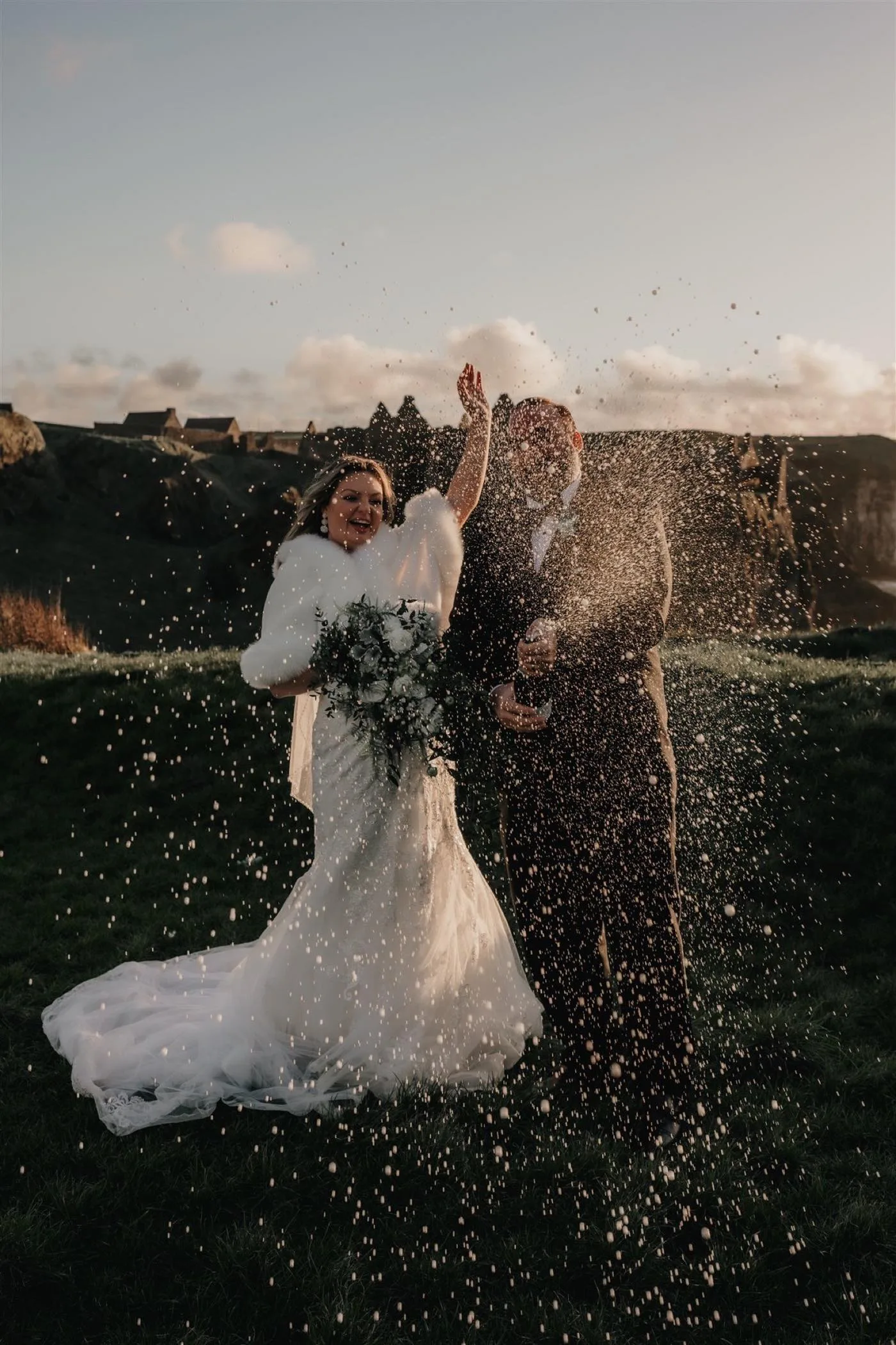 Wedding guests celebrating with confetti in the meadow